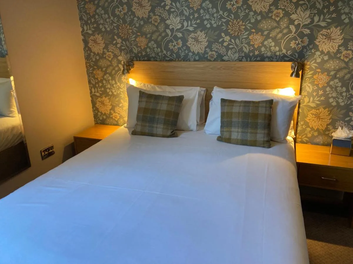 a bedroom with a large white bed with two pillows at The Oxnoble in Manchester