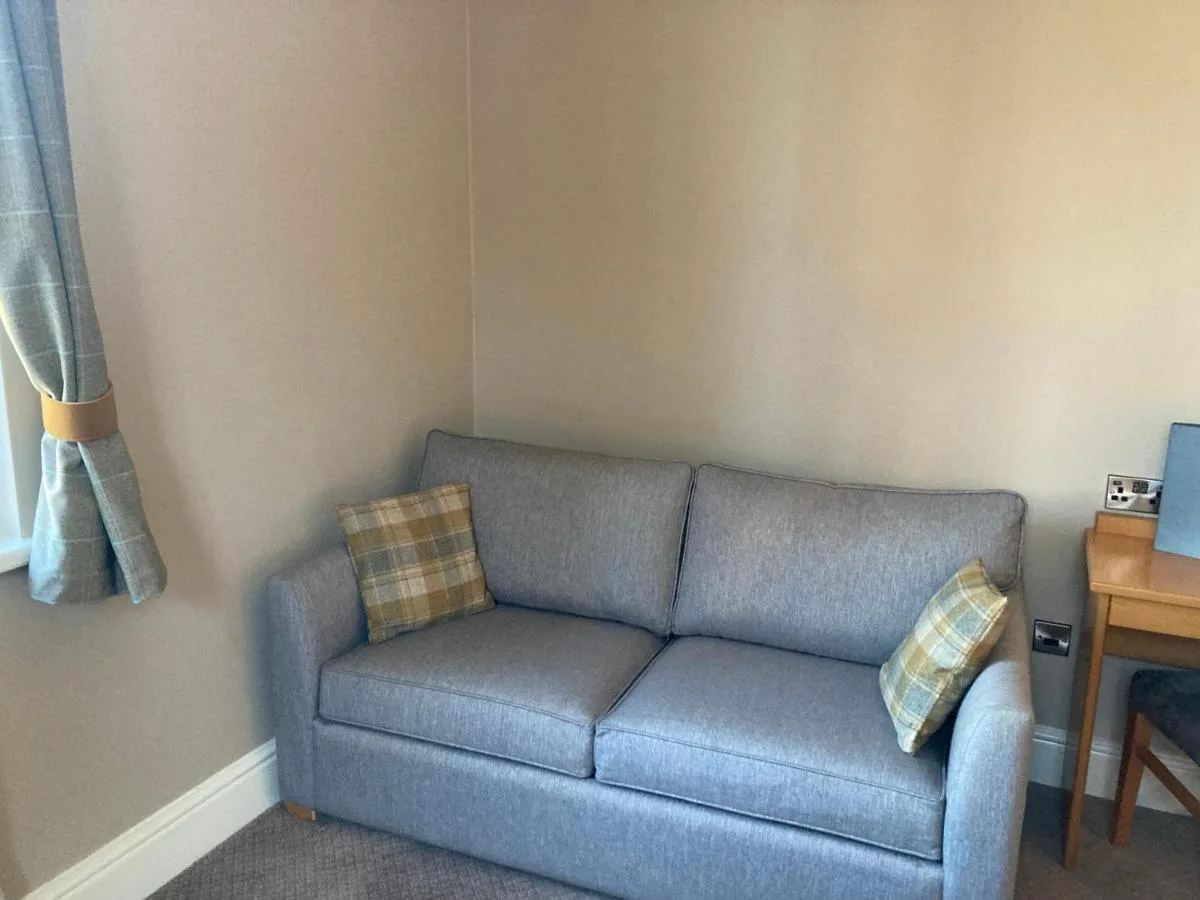 a living room with a couch and a table at The Oxnoble in Manchester