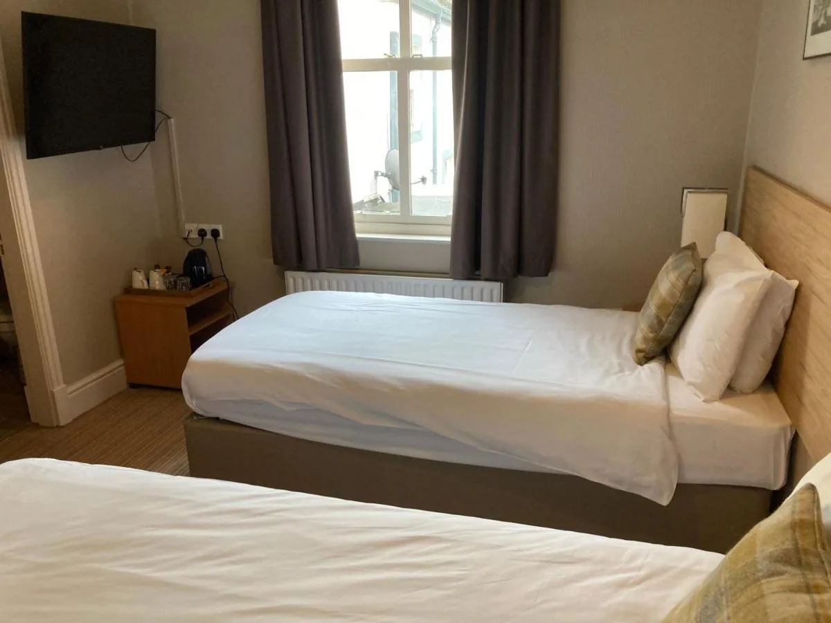 a hotel room with two beds and a television at The Oxnoble in Manchester